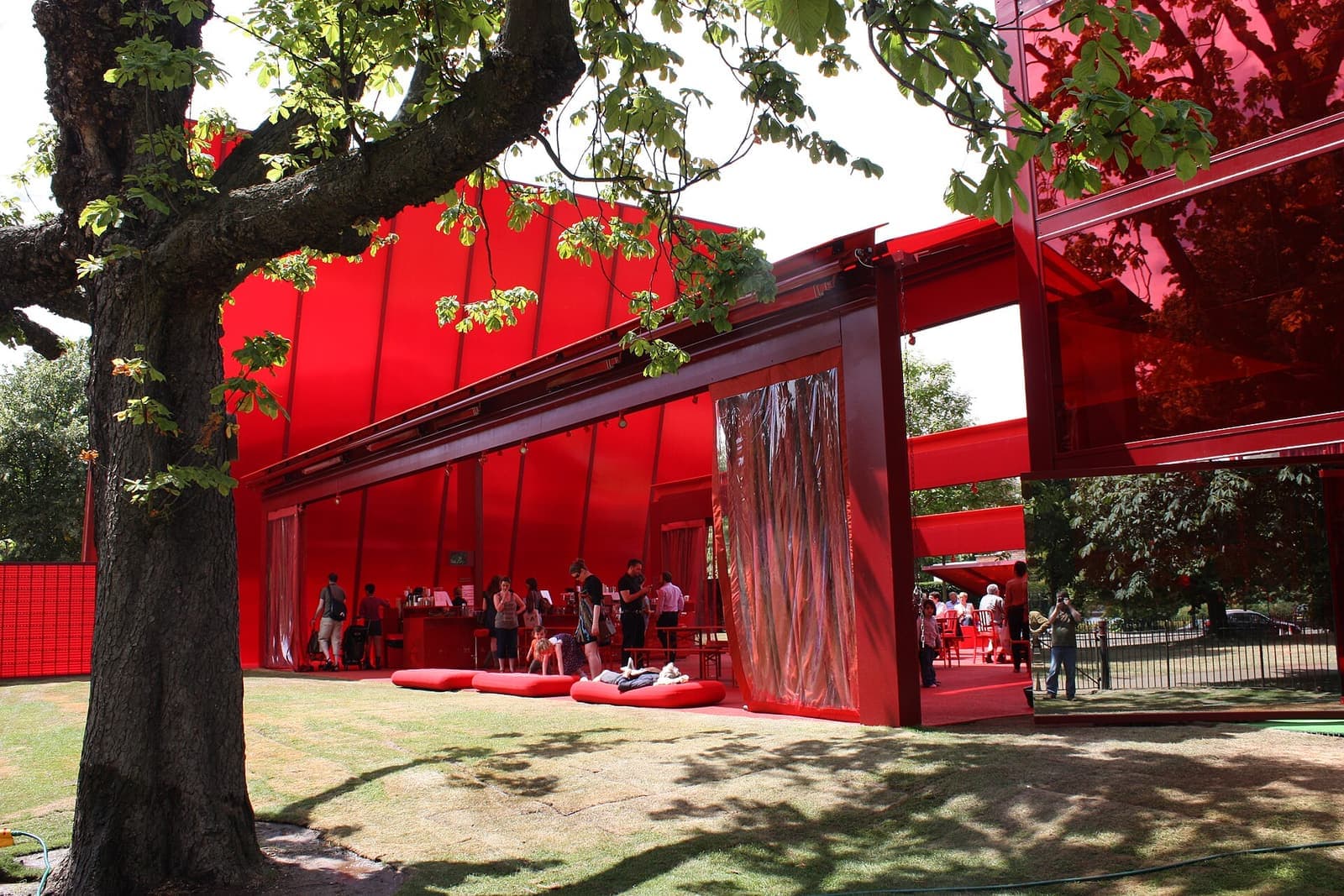 A bright red summer pavilion on the lawn of the Serpentine Gallery