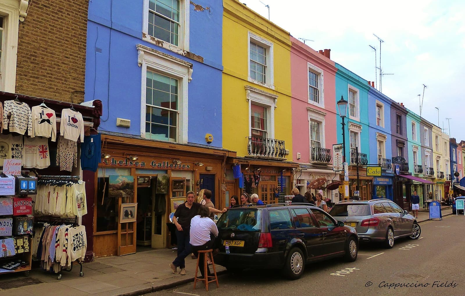 Market stalls in front of coloured houses on Portobello Road
